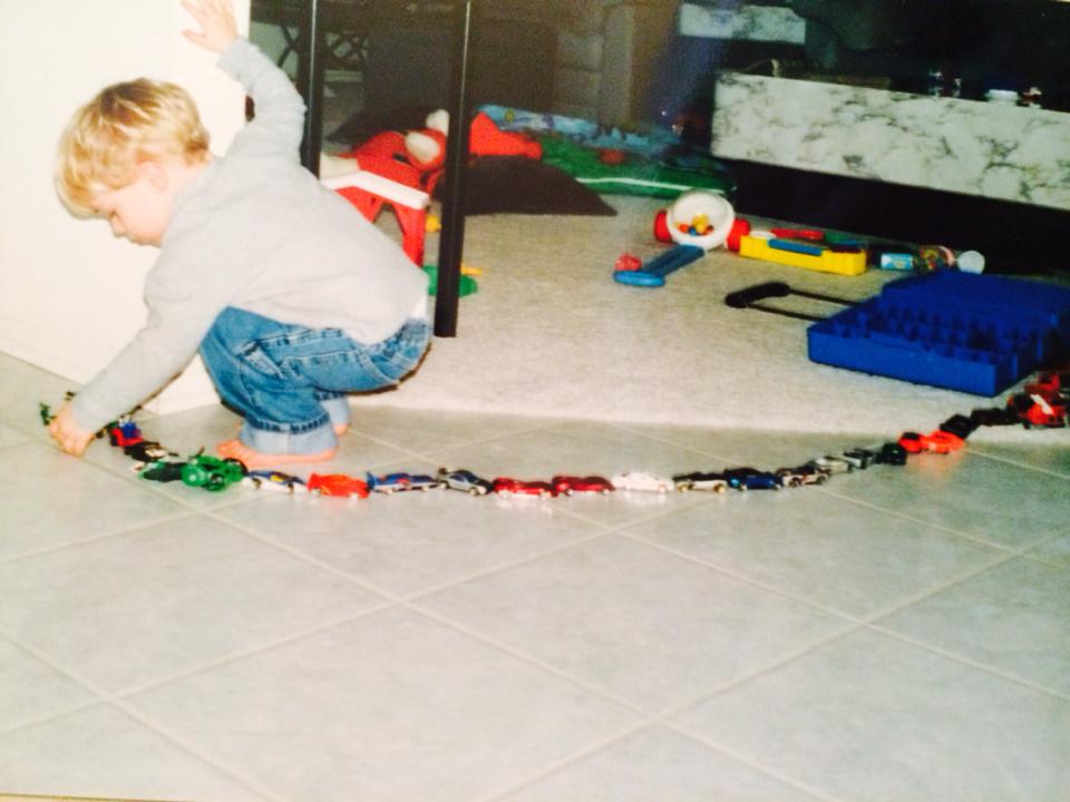 child lining up toys